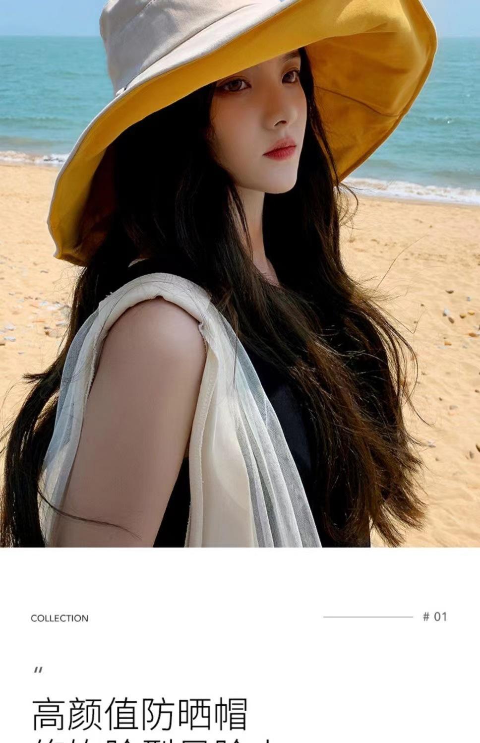 Woman wearing an elegant wide-brim yellow sun hat at the beach