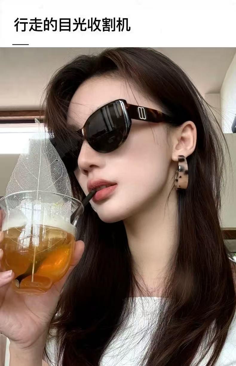 Woman wearing stylish dark sunglasses while enjoying a drink